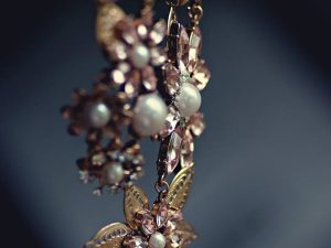 Close-up of a luxurious floral necklace featuring pearls and gemstones with a vintage charm.